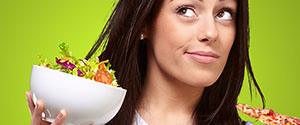 portrait of young woman choosing pizza or salad against a green background