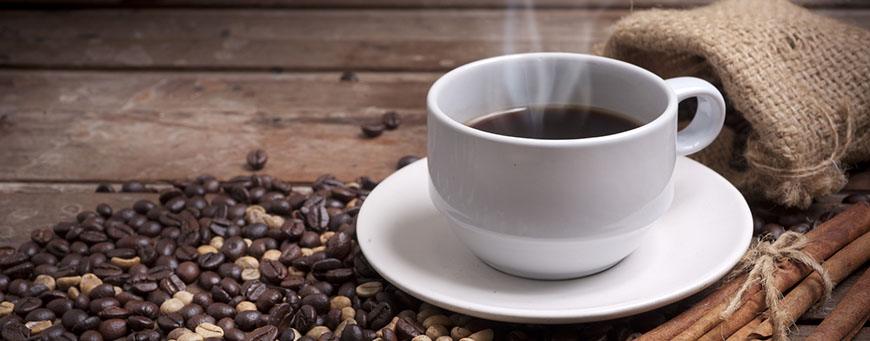 ajwen-bez-kawy-2.jpg Coffee cup and saucer on a wooden table. Dark background.