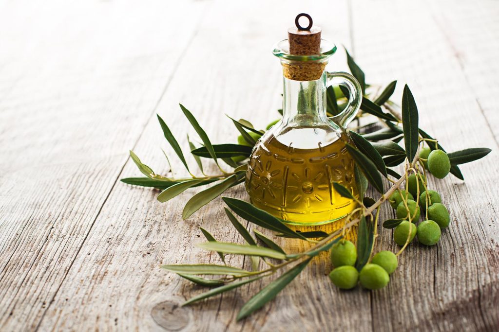 oliwa-z-oliwek-ajwendieta.jpg Olive oil and olive branch on the wooden table
