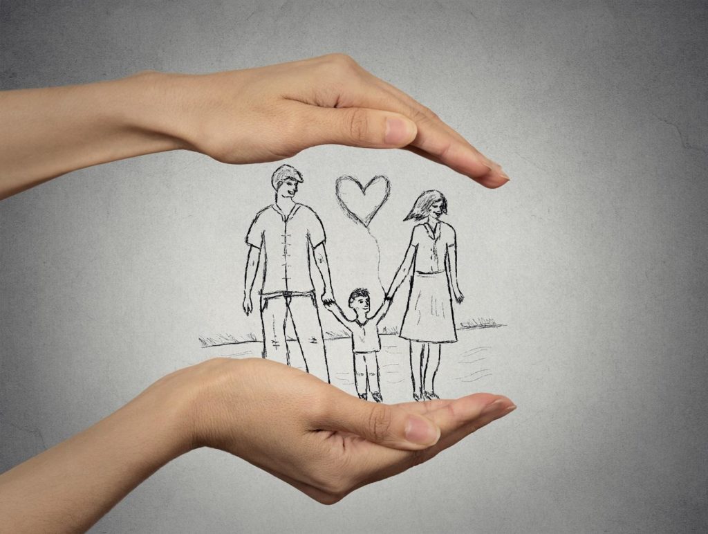 rodzina-zmien-swoje-zycie-dzisiaj.jpg close up of woman's hands protecting happy family, mother, father, child. Family abstract in palms on grey wall background. Safe childhood, parenting. Love care compassion safety secure future concept